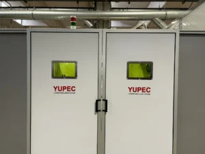 Foto della porta chiusa della cabina di saldatura realizzata da Yupec Service Italia, posizionata in azienda con vista da tre quarti