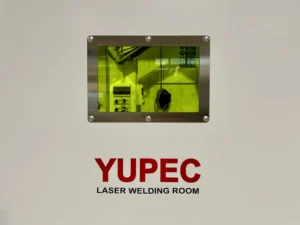 Foto dell'oblò di protezione dai raggi UV Univet sulla porta scorrevole della cabina di saldatura Yupec Service Italia, con la porta chiusa e il logo rosso e nero ben in vista su sfondo bianco